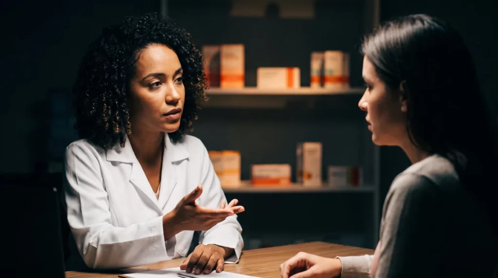 Farmacêutico conversa com paciente em sala de consulta farmacêutica