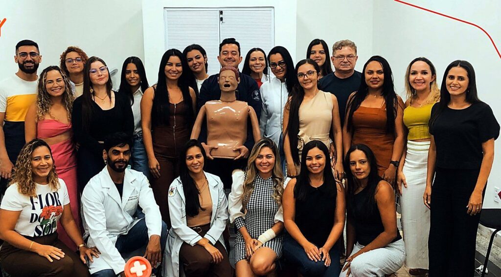 Turma da pós-graduação YnovaPós com o manequim de simulação usado nas aulas práticas